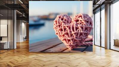 Pink sailor rope curled into a heart shape by the sea. Heart-shaped sailor knots. Wall mural