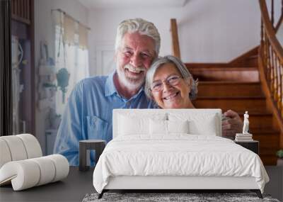 Portrait of couple of two happy and healthy seniors old people smiling and looking at the camera. Close up of mature grandparents enjoying and having fun together at home indoor. Wall mural