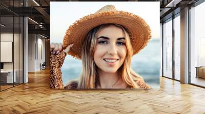 Portrait of one happy beautiful woman on the sand of the beach enjoying and having fun at the sunset of the day. Looking at the camera smiling.. Wall mural