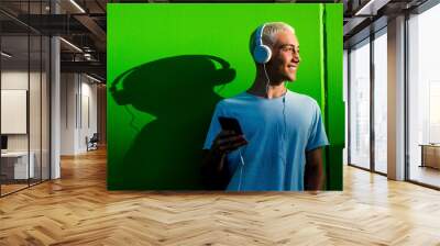 portrait of one teenager or young man listening to music using headphones - millennial having fun hearing music Wall mural