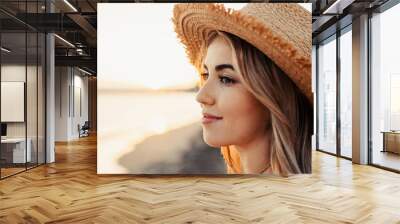 Portrait of one young woman at the beach looking at the sea enjoying free time and freedom outdoors. Having fun relaxing and living happy moments.. Wall mural