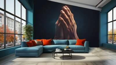 Praying hands with faith in religion and belief in God on dark background. Power of hope or love and devotion. Wall mural