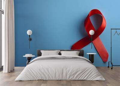 Red ribbon as symbol of aids awareness on blue background Wall mural