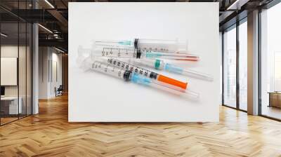 Several syringes in a group. Close up. Could be used to symbolize needle exchange, innoculation or other medical activities. Wall mural