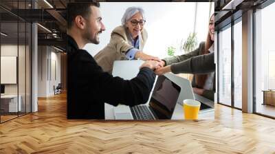 Teamwork. Coworkers joining hands feeling cooperation and team spirit in the office. Wall mural