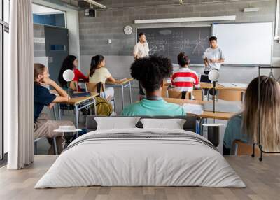 Teen asian boy high school student giving a presentation in class to his multiracial classmates and teacher. Horizontal banner image. Wall mural