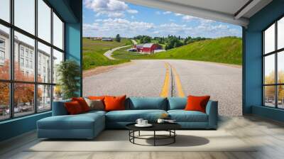 Farm with a red barn on a curving road in the Iowa countryside on a bright spring day Wall mural