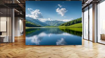 tranquil mountain landscape with calm lake and reflections lush green hills under a serene blue sky with scattered clouds Wall mural