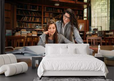 Two female students studying at the library Wall mural