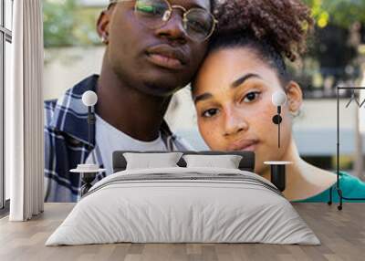 Vertical portrait of African American young couple outdoors looking at camera with serious expression. Wall mural