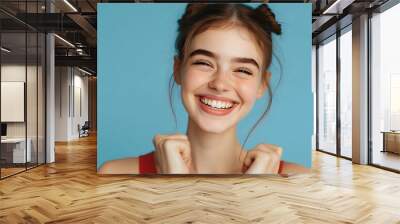 Woman smiling with perfect smile on the blue studio background Wall mural