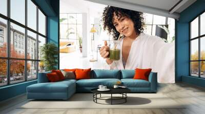 Young african american woman taking selfie drinking green juice reusable bamboo straw Wall mural