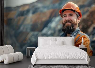 A rugged miner with a beard grins confidently in front of heavy-duty mining machinery Wall mural