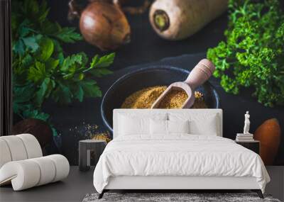 Homemade vegetable broth powder in a black bowl, organic vegetable stock, with raw vegetables on black background Wall mural