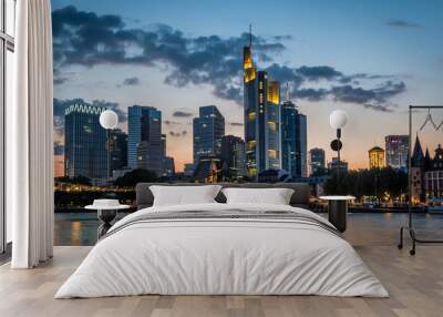 Illuminated skyline of Frankfurt at the bank of Main river after sunset Wall mural