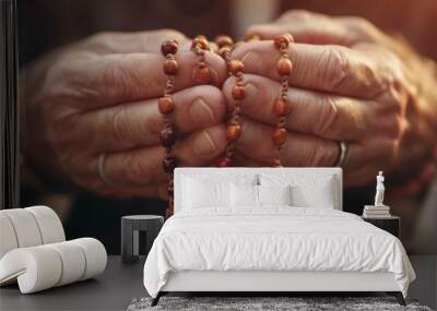 Woman hands holding a rosary and praying in sun backlight Wall mural