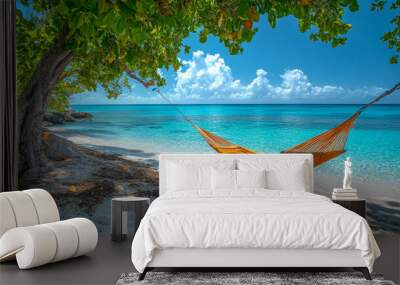 Empty hammock is hanging between two palm trees on a tropical beach with turquoise water and white sand Wall mural