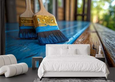 Two paintbrushes are painting wooden deck boards blue on a sunny day Wall mural