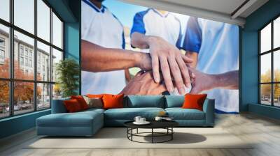 Sports, huddle and football team with their hands together on the ball for motivation, empowerment or unity. Fitness, group and athletes or soccer players in a circle before game, match or tournament Wall mural