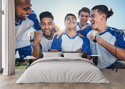 Win, football player and men celebrate together on a field for sports and fitness achievement. Happy male soccer team or athlete group with fist for challenge, competition or pride outdoor on pitch Wall mural