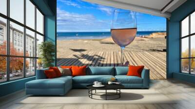 A glass of rose wine against a backdrop of beach, ocean and kitesurfing. A romantic end to the day Wall mural