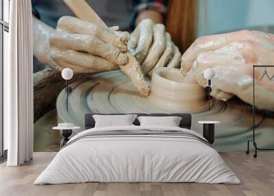 Couple hands sculpting clay pot at the pottery's wheel. Date at the pottery workshop. Closeup picture. Wall mural