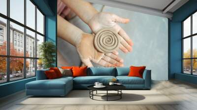 Kid's hands hold clay product. New hobby. Pottery workshop. Wall mural