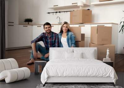 Happy couple with unpacked boxes in kitchen Wall mural