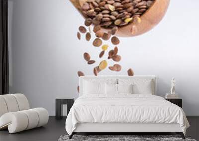 Spoon of lentil falling on a white background Wall mural