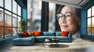 A close up shot of an asian elder woman smiling looking side. Wall mural