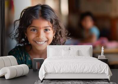 A smart smiling Indian child girl posing in the classroom. Wall mural