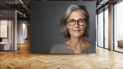 Close up middle aged woman wearing eyeglasses smiling isolated over gray background Wall mural