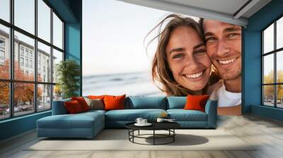 Close up portrait of a beautiful young couple smiling on a summer day at the beach Wall mural