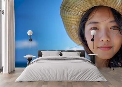 Cropped of an asian woman wearing straw hat at the beach Wall mural