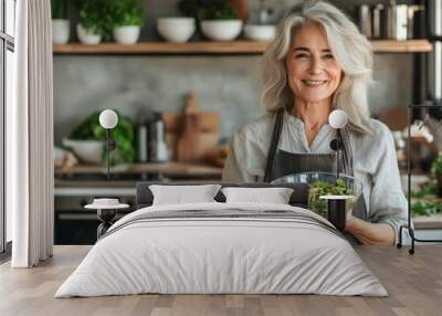 healthy eating, food cooking and culinary concept - happy smiling senior woman holding vegetable salad on kitchen at home Wall mural