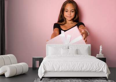 picture of happy little girl child standing isolated over pink background. looking camera holding gi Wall mural