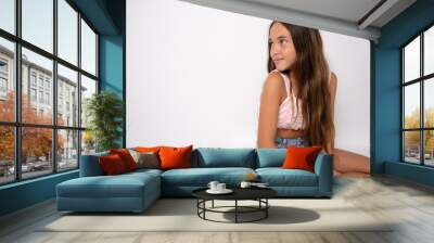 young 11 year old girl sit on floor rest with a smile into camera with copy space isolated on white Wall mural