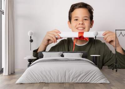 Young little caucasian student kid holding school degree over white isolated background with a happy face Wall mural