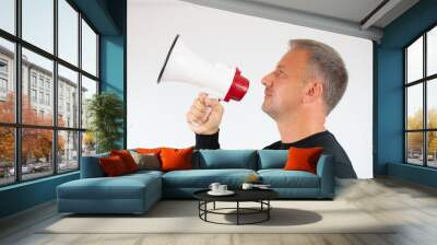 Young man talking in the megaphone on white background Wall mural