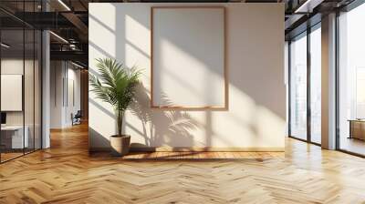 A blank poster frame on the wall of an empty room with wooden floors, sunlight shining through the window casting shadows across the floor Wall mural