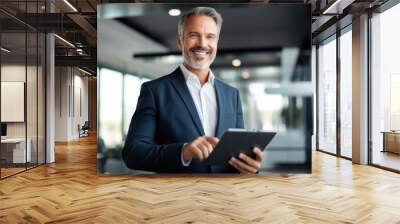 portrait of professional businessman standing in office. Happy middle aged businessman ceo wearing suit standing in office using digital tablet. Wall mural