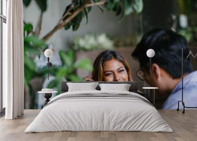 A young, tanned and attractive Southeast Asian woman in a suit is interviewing for a job to advance her career. She is smiling as she talks to her interviewer, a Chinese manager in a coworking office. Wall mural