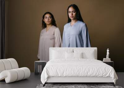 portrait of two young middle eastern muslim women as they pose for their photo. they are wearing tra Wall mural