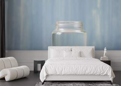 Close up of a lone goldfish in a clear water-filled jar on a light background Wall mural