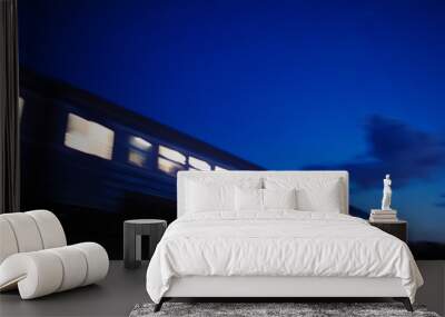 Illuminated train traveling past at night Wall mural