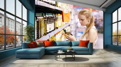 young woman buying olive oil Wall mural