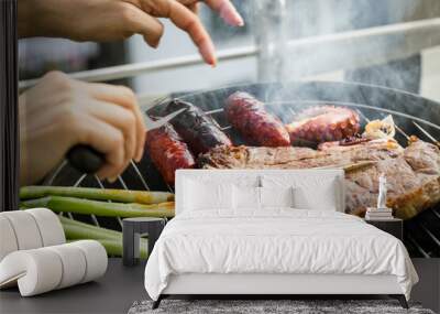 Close-up view of woman‘s hands and animal products in a hot and smokey grill Wall mural