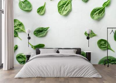 Fresh spinach leaves scattered on a white background, bright and textured Wall mural