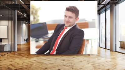 Young employee looking at computer monitor during working day in office Wall mural