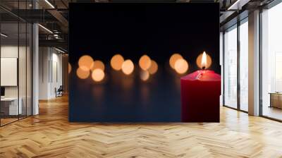 The burning red candle in the dark background.  Wall mural